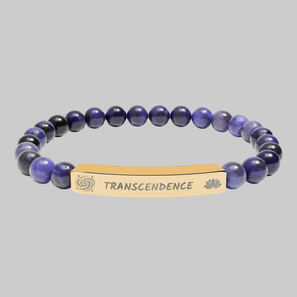 Beaded bracelet with a gold tone tag saying Transcendence with galaxy spiral and lotus symbols