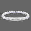 Beaded bracelet with a silver tag saying Transcendence with galaxy and lotus symbols